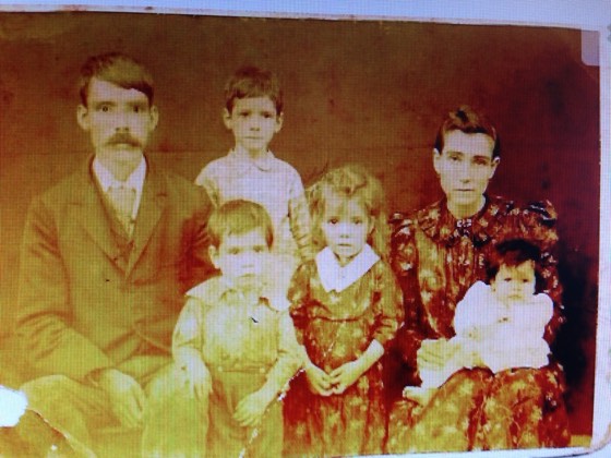 A family of seven in a hand-tinted portrait