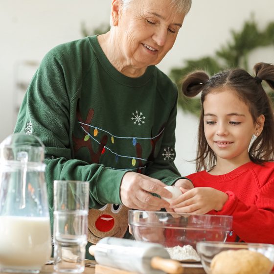 A grandmother and granddaughter baking at Christmas