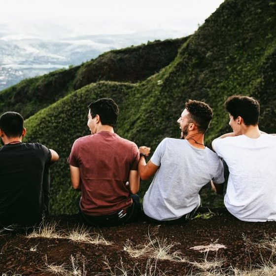 Four friends sitting on a hilltop