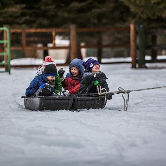 Three children on a sled in the snow